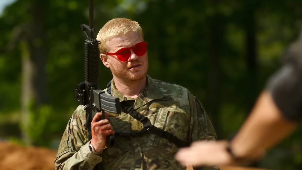 Jesse Plemons as a soldier holding a gun and wearing red glasses in Civil War